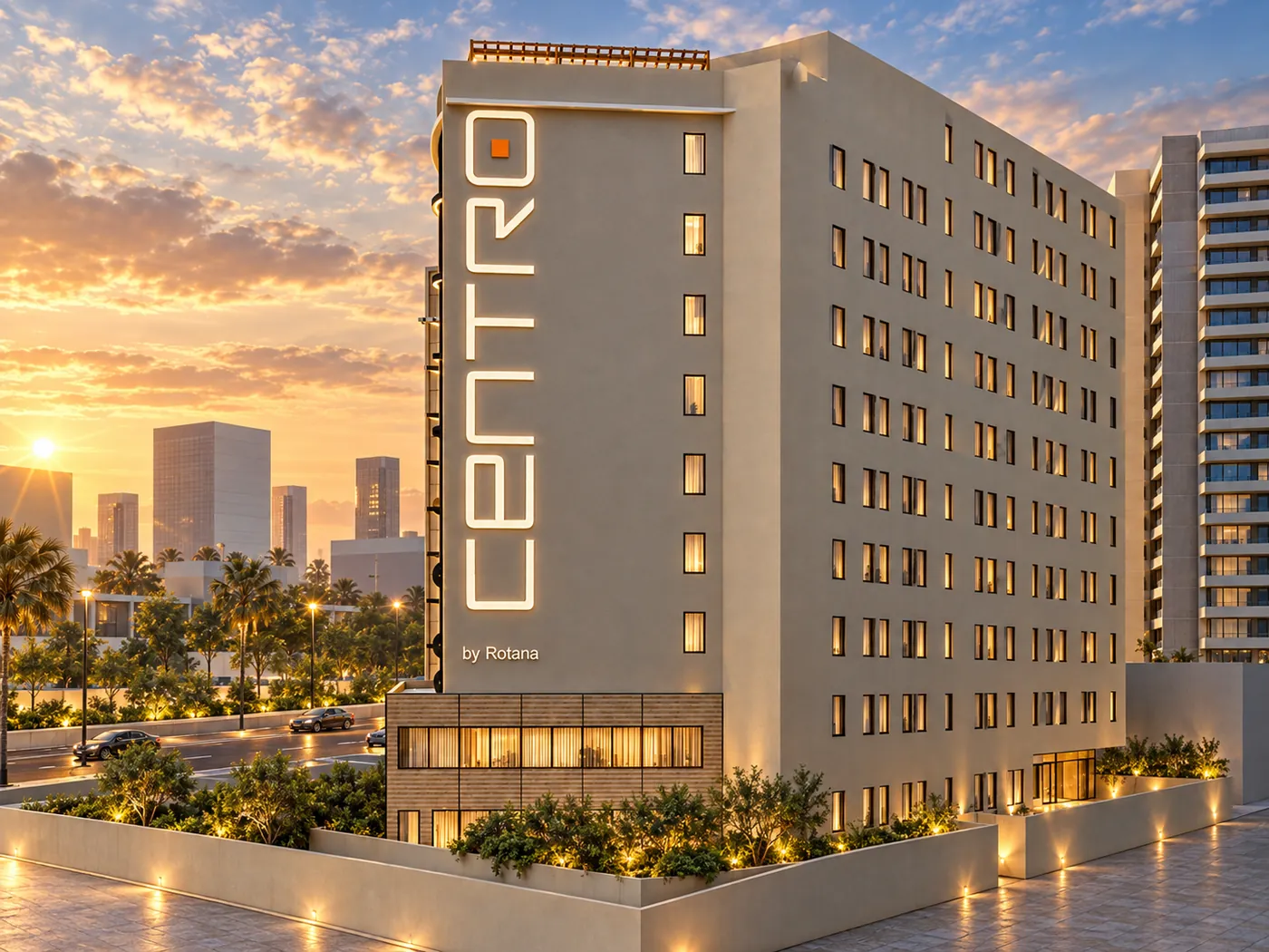 The solid service wall with punched windows and the full-height Centro sign, lit at dusk above the podium.
