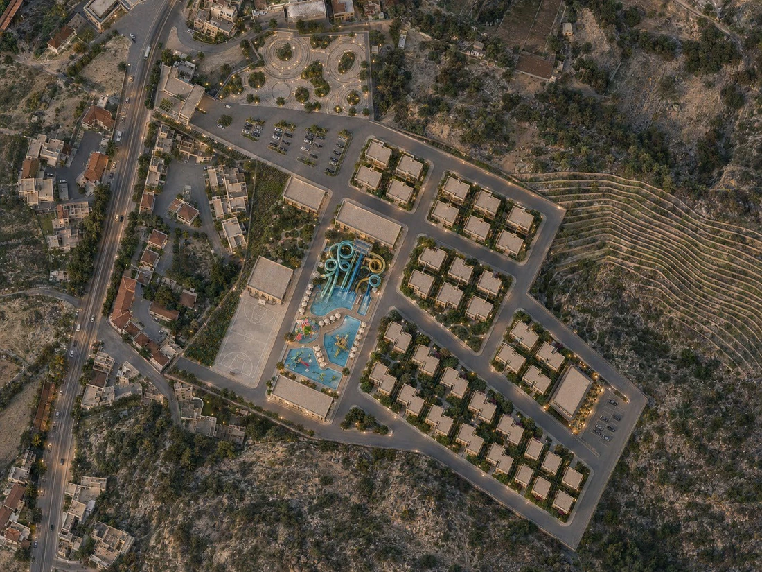 Rendered aerial master plan showing villa rows, the aqua park, sports court and parking against the natural slope.