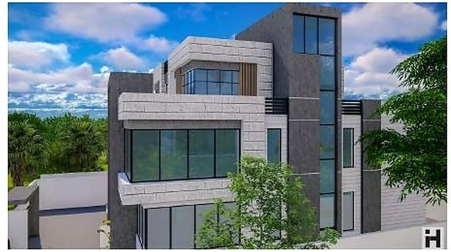 The glass-cornered villa from the garden, stone cladding and deep reveals.
